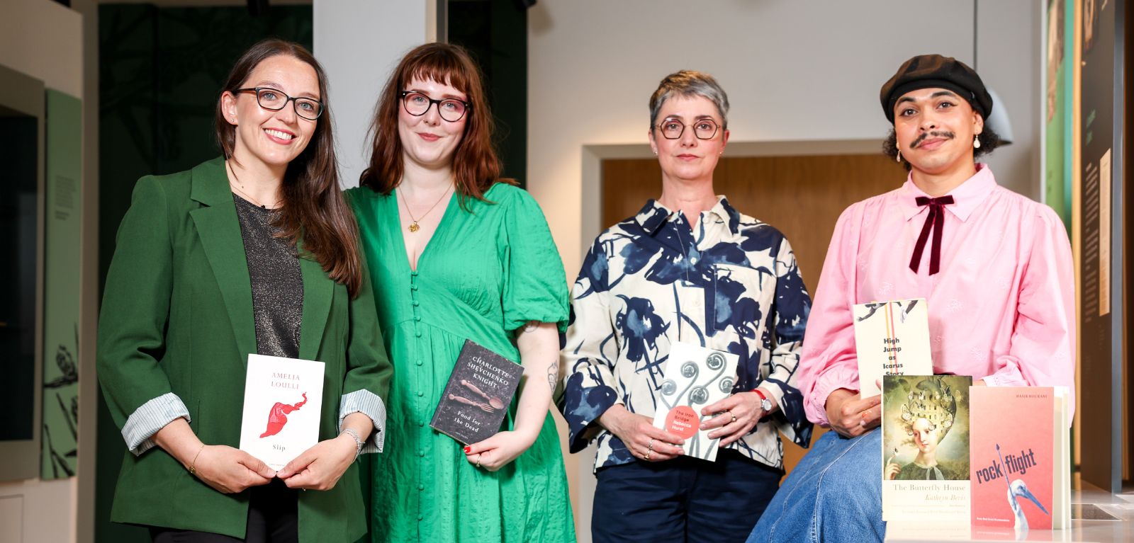 A group of people standing in a row holding books